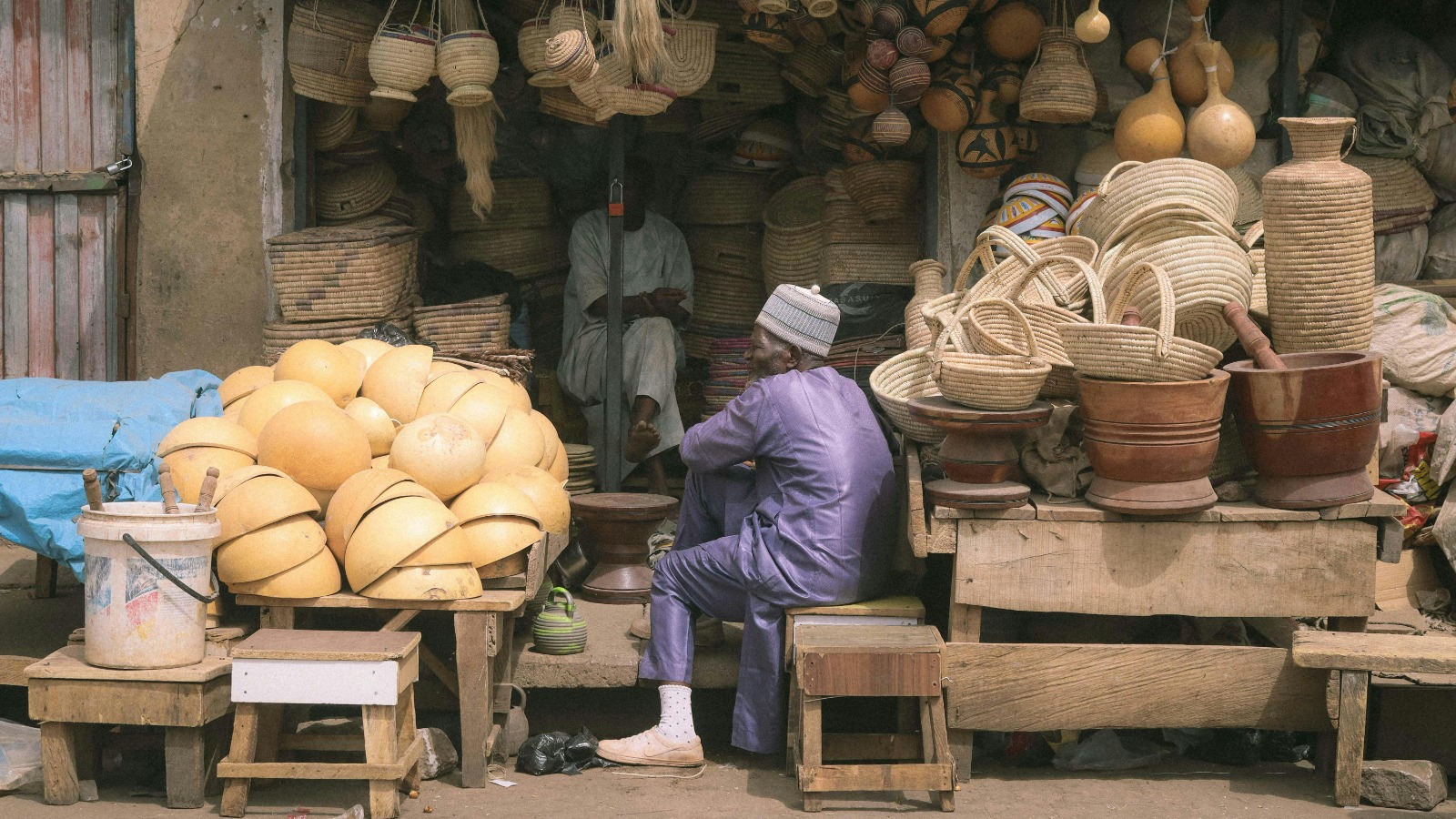 Trader checking phone with a thoughtful expression in a market